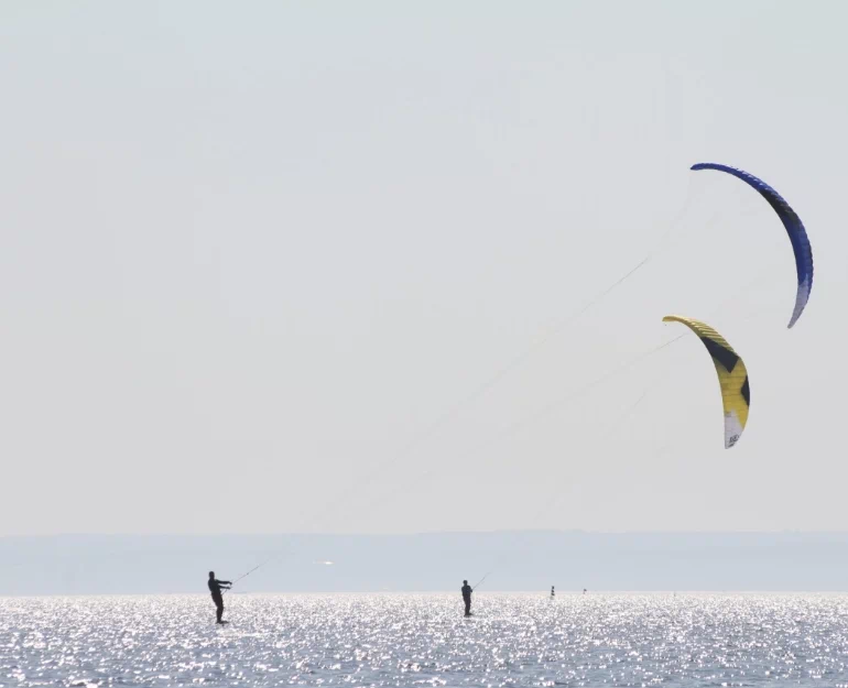 ludzie na morzu podczas kitesurfingu